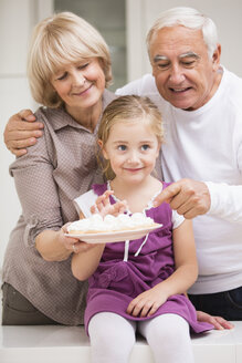 Porträt eines älteren Paares mit Enkelin in der Küche - WESTF019109