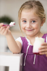Porträt eines kleinen Mädchens, das Joghurt anbietet - WESTF019117