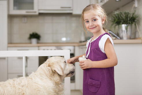 Kleines Mädchen füttert Hund mit Joghurt - WESTF019185