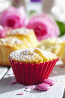Muffins, Backdekor und rosa Rosen auf dem Tisch - CSF021070