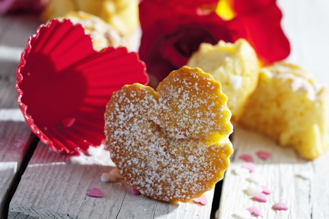 Muffins, Backdekor und rote Rose auf dem Tisch, lizenzfreies Stockfoto