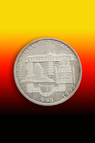 Old German commemorative coin in front of national colours stock photo