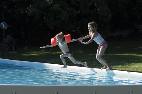 Italien, Toskana, Kinder springen ins Schwimmbad, lizenzfreies Stockfoto