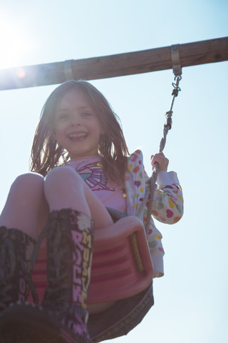 Portrait of smiling little girl on swing stock photo