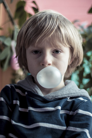 Portrait of little bow blowing gum bubble stock photo