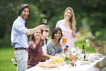 Mann stößt mit Rotwein auf einer Gartenparty an - ABF000582