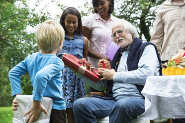 Großvater erhält Geschenke auf Geburtstagsfeier im Garten - ABF000565