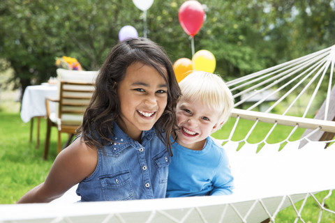 Smiling boy and girl in hammock stock photo