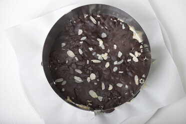 Tortenboden mit gehobelten Mandeln und Zartbitterschokolade im Tortenring, Ansicht von oben - CSTF000204