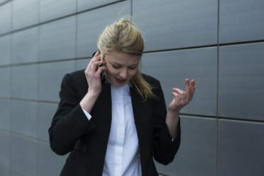 Germany, Mannheim, Young businesswoman using mobile phone - UUF000010