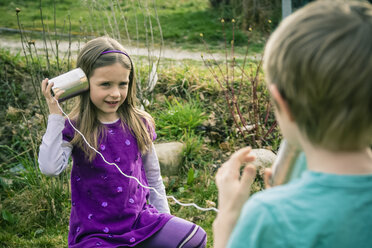 Boy and girl playing with tin can phone - SARF000410