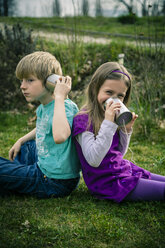 Boy and girl playing with tin can phone - SARF000409