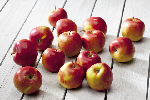 Braeburn-Äpfel auf grauem Holztisch, lizenzfreies Stockfoto