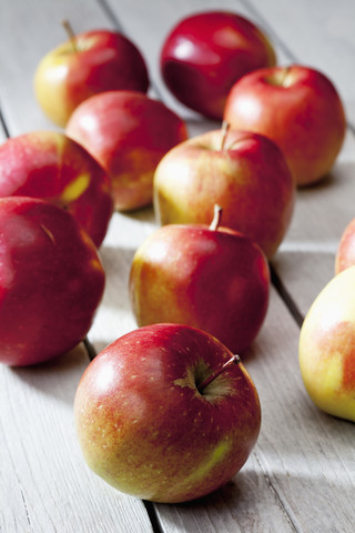 Braeburn-Äpfel auf grauem Holztisch, lizenzfreies Stockfoto