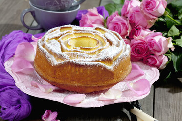 Geburtstagskuchen auf Kuchenstand und Rosen im Hintergrund - CSF021145