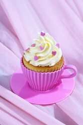 Backform in Form einer Tasse mit dekoriertem Cupcake auf rosa Tuch - CSF021142