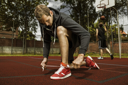 Young basketball player doing up the shoelaces - GCF000006