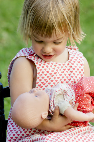 Kleines Mädchen spielt mit Puppe, lizenzfreies Stockfoto