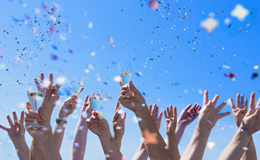 People exulting, Arms raised with champagne glasses, confetti - DIKF000081