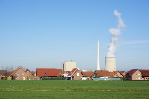 Deutschland, Nordrhein-Westfalen, Petershagen-Lahde, Stadt mit Einfamilienhäusern und einem Kohlekraftwerk im Hintergrund. - HAWF000013