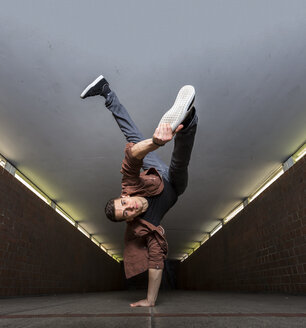 Junger Breakdancer macht einen Handstand in einer Unterführung - STSF000389