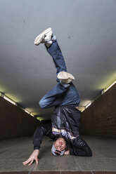 Junger Breakdancer macht einen Kopfstand in einer Unterführung - STSF000391