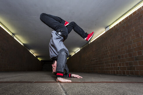 Junger Breakdancer macht einen Handstand in einer Unterführung - STSF000390