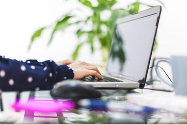 Young woman working with laptop at home, partial view - EBSF000119