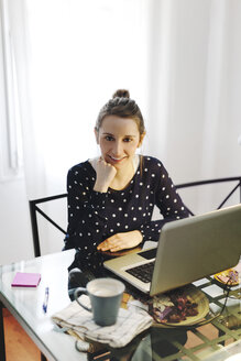 Junge Frau bei der Arbeit mit Laptop zu Hause - EBSF000143