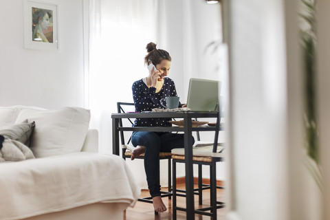 Young woman working with laptop at home stock photo