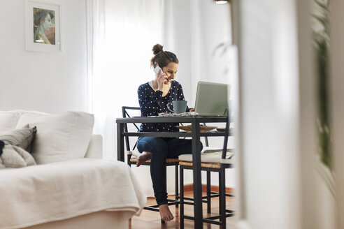 Junge Frau bei der Arbeit mit Laptop zu Hause - EBSF000144