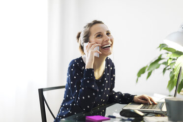 Young woman telephoning with smartphone at home - EBSF000123