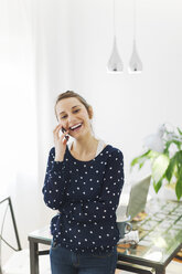 Young woman telephoning with smartphone at home - EBSF000126