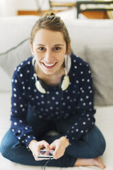 Portrait of young woman with smartphone at home - EBSF000132