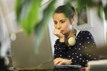 Junge Frau bei der Arbeit mit Laptop zu Hause - EBSF000134