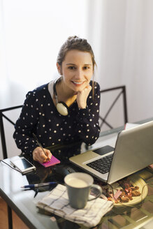 Junge Frau bei der Arbeit mit Laptop zu Hause - EBSF000148