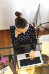 Junge Frau bei der Arbeit mit Laptop zu Hause - EBSF000138