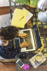 Junge Frau bei der Arbeit mit Laptop zu Hause - EBSF000140