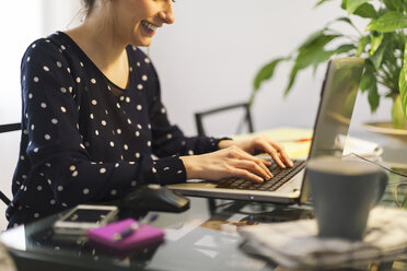 Junge Frau bei der Arbeit mit Laptop zu Hause, Teilansicht - EBSF000141