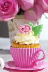 Backform in Form einer Tasse mit dekorierten Cupcakes vor rosa Rosen - CSF021179