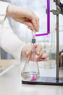Female scientist filling liquid in test tube, partial view - NAF000005