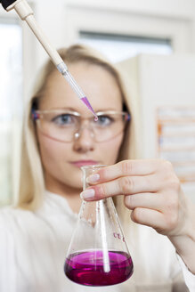 Portrait of female scientist filling liquid in test tube - NAF000006