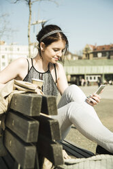 Portrait of young woman with coffee to go using smartphone - UUF000135