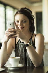 Portrait of young woman using smartphone at cafe - UUF000075