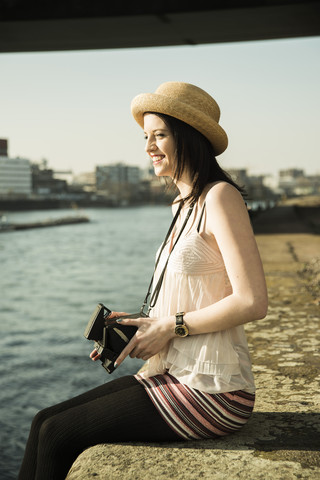 Porträt einer jungen Frau mit alter Kamera und Sommerhut, lizenzfreies Stockfoto