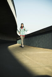 Young female jogger on the move on a bridge - UUF000101