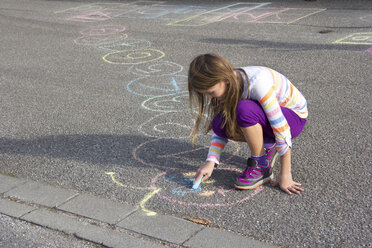 Girl drawing with coloured crayon on asphalt - YFF000082