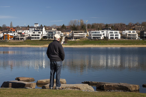 Germany, North Rhine-Westphalia, Dortmund-Hoerde, Lake Phoenix, Senior standing at lakeshore stock photo