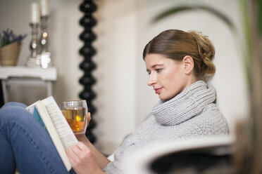 Porträt einer lesenden Frau, die den Sonntagmorgen zu Hause genießt - NNF000007