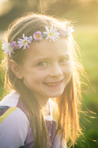 Porträt eines lächelnden kleinen Mädchens mit Blumen, lizenzfreies Stockfoto